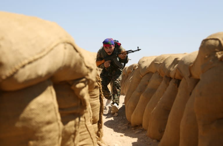 A fighter from the Kurdish People Protection Unit walks between sandbags on the front line in the northeastern Syrian city of Hasakeh on September 4, 2015