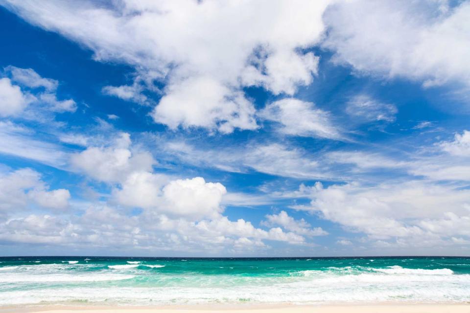 Fluffy white clouds, blue sky, and turquoise water at Eleuthera Island, Bahamas