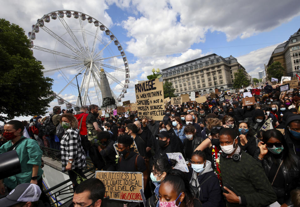 Protesters hold placards as they gather in central Brussels during the Black Lives Matter protest rally, Sunday, June 7, 2020. The demonstration was held in response to the recent death of George Floyd by police officers in Minneapolis, which has led to protests in many countries and across the US. (AP Photo/Olivier Matthys)