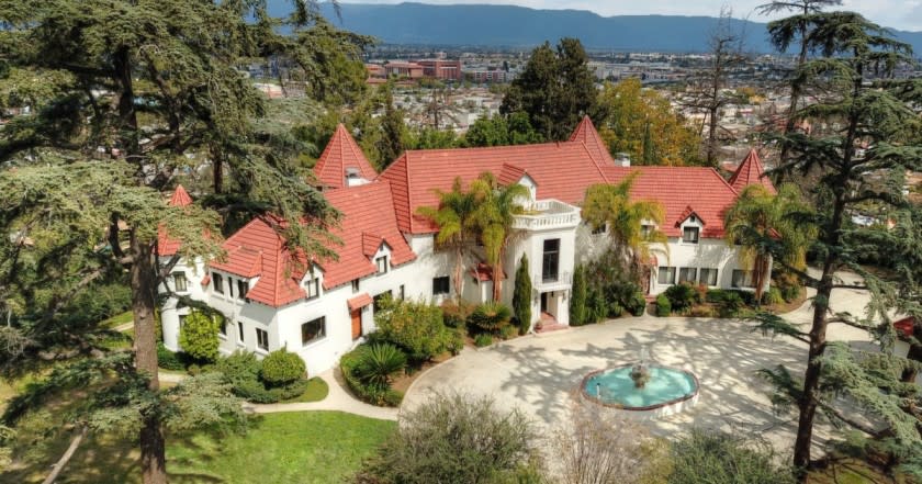 Known as the Pyrenees Castle, the 1925 mansion sits behind walls and gates on a 2.6-acre knoll in Alhambra.