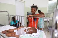 Dorvil Chiloveson, 3, swollen with edema, is watched over by his mother Linda Julien, 20, in the malnutrition ward at St. Damien Pediatric Hospital in Port-au-Prince