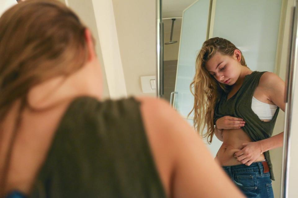 <span class="caption">An eating disorder is not about managing weight; it’s about managing emotions.</span> <span class="attribution"><a class="link " href="https://www.gettyimages.com/detail/photo/young-woman-pinching-her-waist-royalty-free-image/530019617?adppopup=true" rel="nofollow noopener" target="_blank" data-ylk="slk:Getty Images / PhotoStock-Israel;elm:context_link;itc:0;sec:content-canvas">Getty Images / PhotoStock-Israel</a></span>
