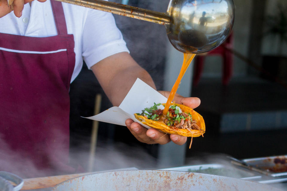 A chef preparing a birria taco.