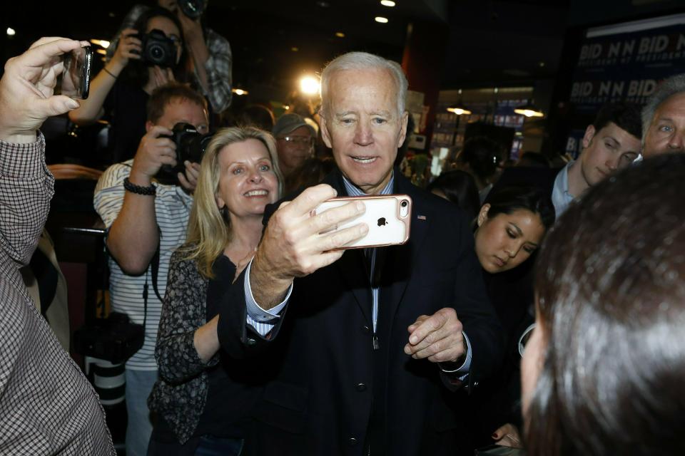 Former vice president and Democratic presidential candidate Joe Biden takes a selfie with a reporter during a campaign stop at the Community Oven in Hampton, N.H., Monday, May 13, 2019. (AP Photo/Michael Dwyer)