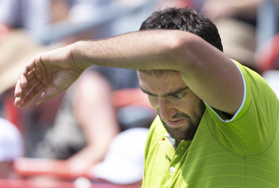 Marin Cilic of Croatia wipes his face during his match against Dominic Thiem of Austria during the Rogers Cup men’s tennis tournament Thursday, Aug. 8, 2019, in Montreal. (Paul Chiasson/The Canadian Press via AP)