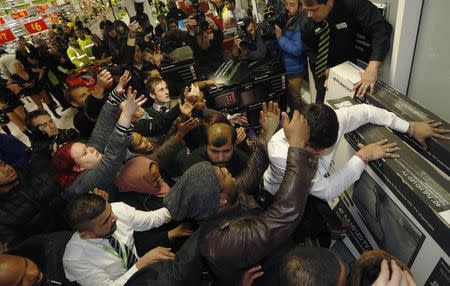 Shoppers compete to purchase retail items on "Black Friday" at an Asda superstore in Wembley, north London November 28, 2014. REUTERS/Luke MacGregor