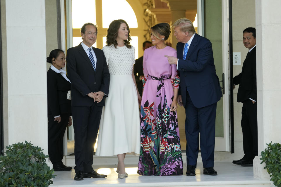 Former President Donald Trump, right, stands with Melania Trump, second from right, as they are greeted by John Paulson, left, and Alina de Almeida, second from left, at a GOP fundraiser, Saturday, April 6, 2024, in Palm Beach, Fla. (AP Photo/Lynne Sladky)