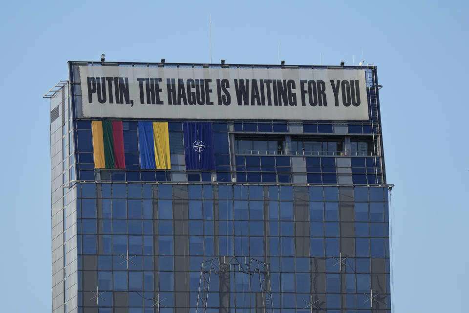 A banner hangs on the upper part of a building in the center of the city during a NATO summit in Vilnius, Lithuania, Tuesday, July 11, 2023. Ukrainian President Volodymyr Zelenskyy on Tuesday blasted as "absurd" the absence of a timetable for his country's membership in NATO, injecting harsh criticism into a gathering of the alliance's leaders that was intended to showcase solidarity in the face of Russian aggression. (AP Photo/Pavel Golovkin)