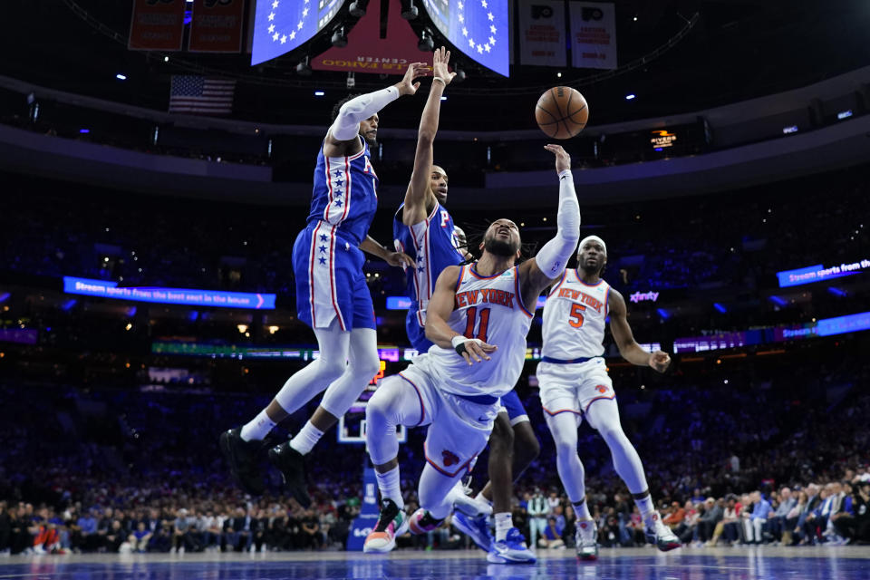 New York Knicks' Jalen Brunson (11) tries to get a shot past Philadelphia 76ers' Tobias Harris, left, and Nicolas Batum during the second half of Game 3 in an NBA basketball first-round playoff series, Thursday, April 25, 2024, in Philadelphia. (AP Photo/Matt Slocum)