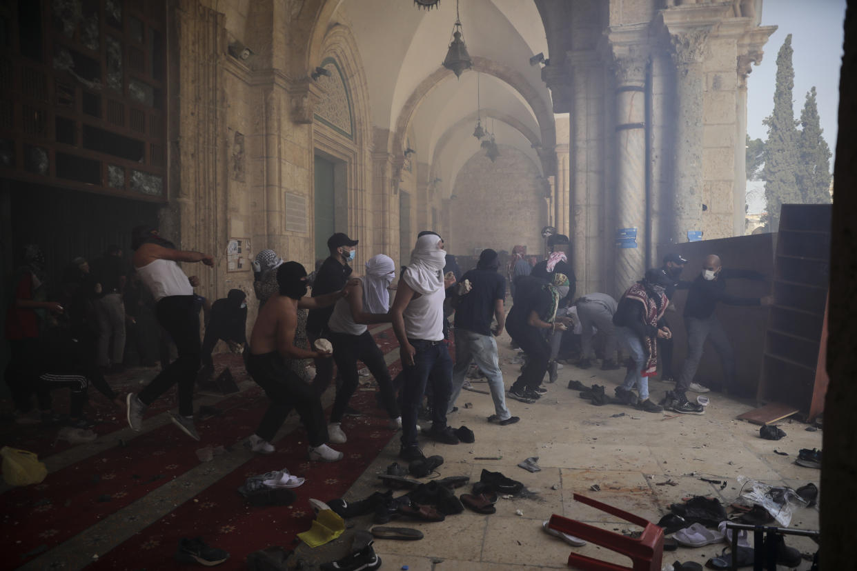 Palestinians clash with Israeli security forces at the Al Aqsa Mosque compound in Jerusalem's Old City Monday, May 10, 2021. Israeli police clashed with Palestinian protesters at a flashpoint Jerusalem holy site on Monday, the latest in a series of confrontations that is pushing the contested city to the brink of eruption. Palestinian medics said at least 180 Palestinians were hurt in the violence at the Al-Aqsa Mosque compound, including 80 who were hospitalized. (AP Photo/Mahmoud Illean)