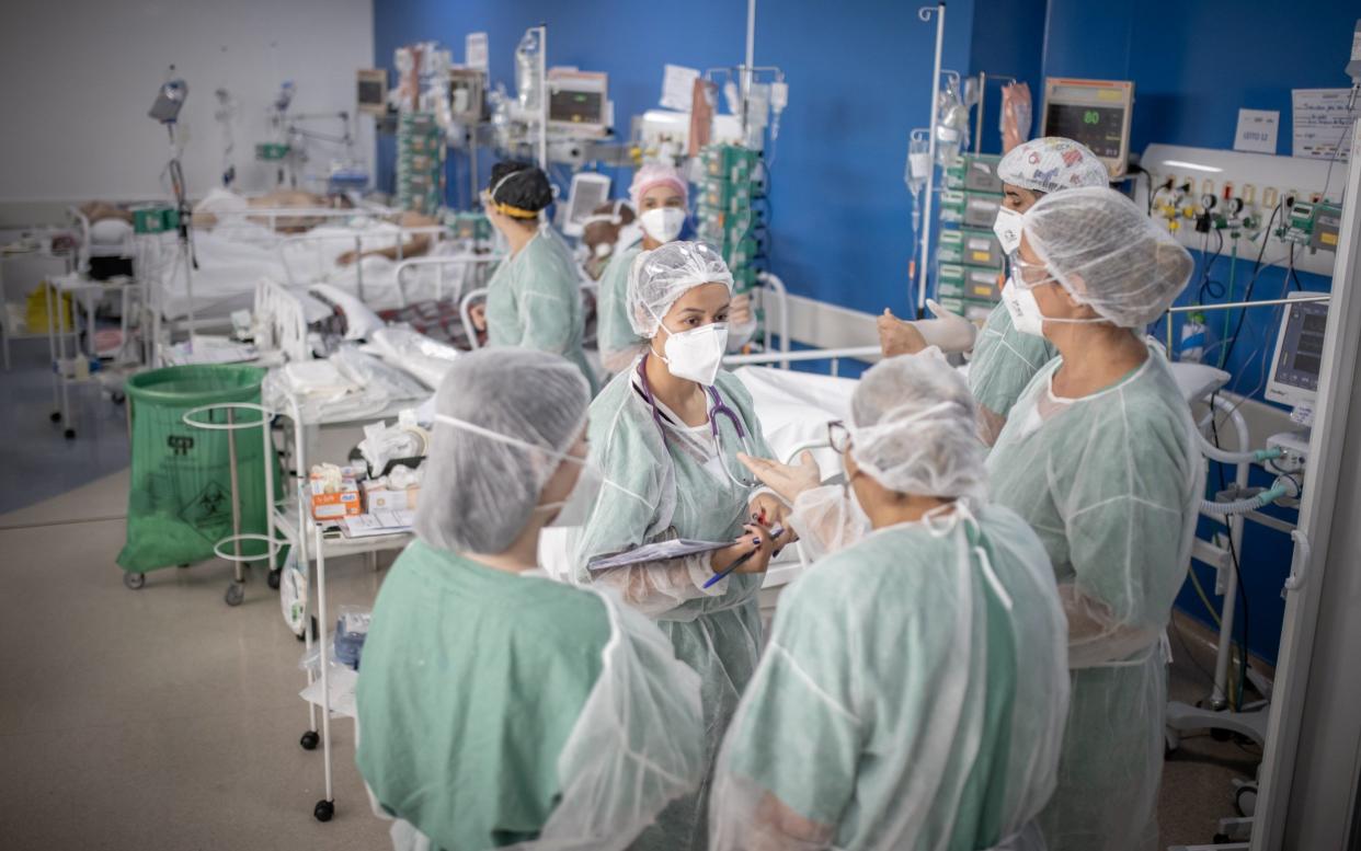 Healthcare workers treat patients inside a Covid-19 intensive care unit (ICU) at a field hospital in the Heliopolis favela of Sao Paulo, Brazil, on Friday, March 19, 2021