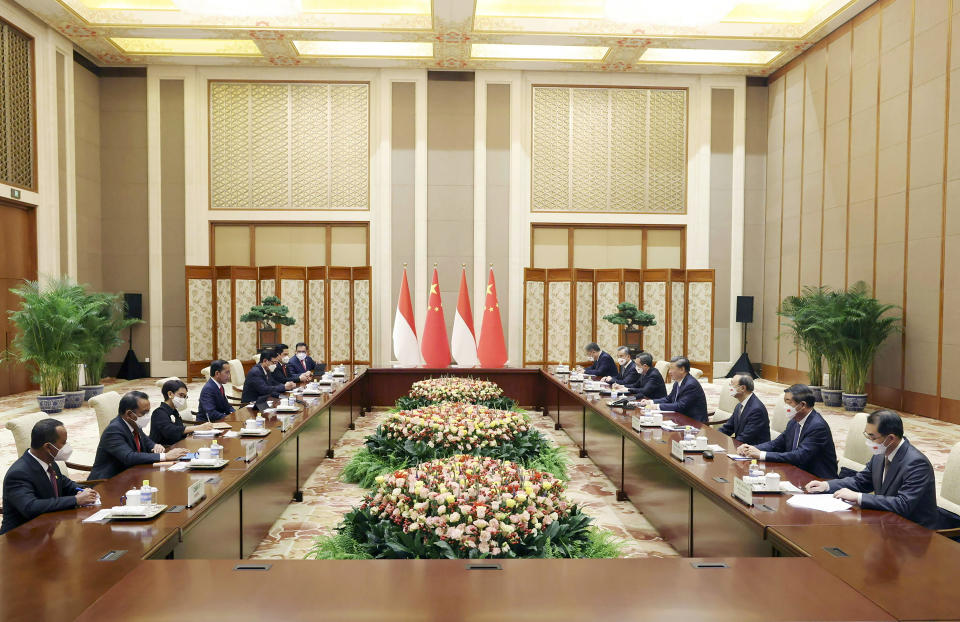 In this photo released by China's Xinhua News Agency, Indonesian President Joko Widodo, center left, and Chinese President Xi Jinping, center right, meet at the Diaoyutai State Guesthouse in Beijing, Tuesday, July 26, 2022. Widodo on Tuesday formally invited Xi Jinping to the Group of 20 summit in Bali this fall, although it's unclear whether the Chinese leader would attend in person. (Liu Weibing/Xinhua via AP)