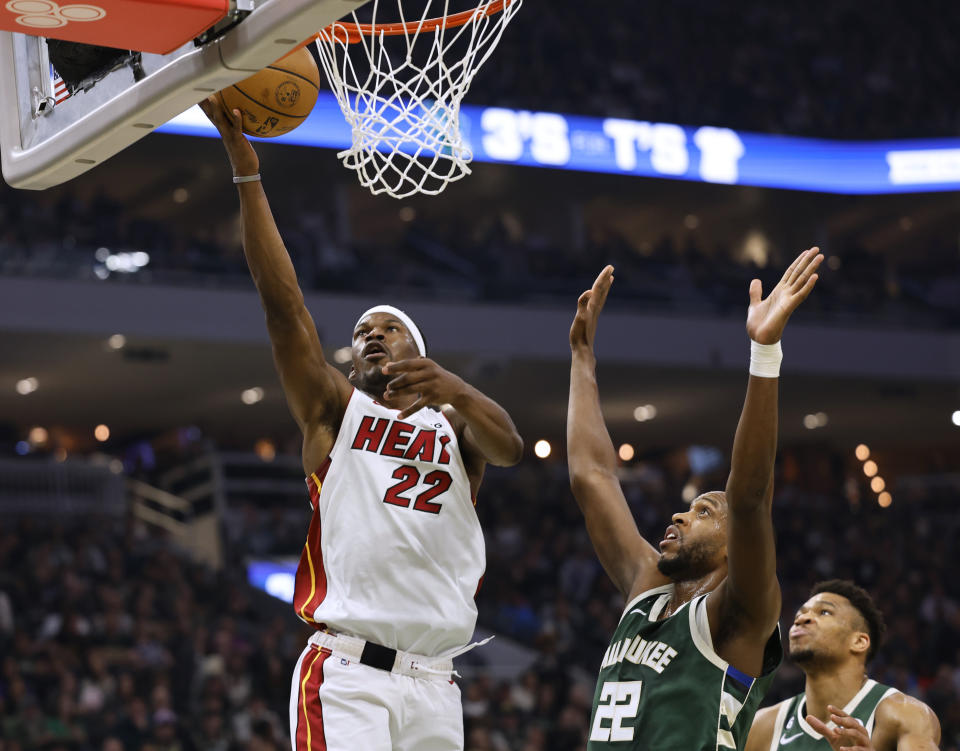 Miami Heat forward Jimmy Butler, left, shoots next to Milwaukee Bucks forward Khris Middleton during the first half of Game 5 in a first-round NBA basketball playoff series Wednesday, April 26, 2023, in Milwaukee. (AP Photo/Jeffrey Phelps)
