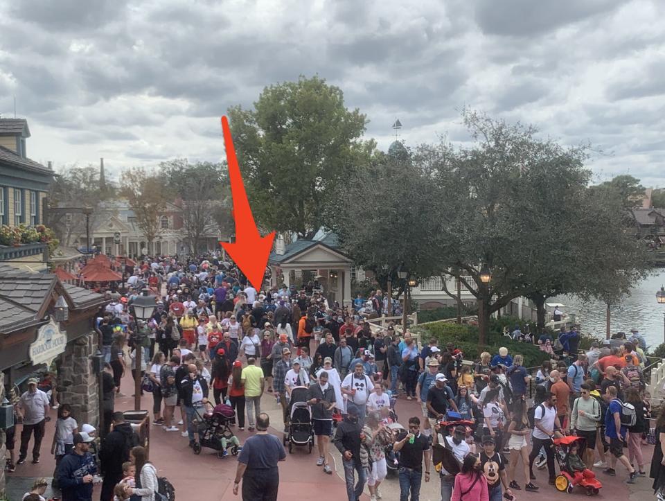 an arrow pointing to the writer and her family in a massive crowd at haunted mansion