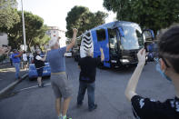 Fans wave as the coach of Atalanta team arrives, prior to the Serie A soccer match between Atalanta and Sassuolo at the Gewiss Stadium in Bergamo, Italy, Sunday, June 21, 2020. This is the first game to be played in Bergamo since easing of lockdown measures, in the area that has been the epicenter of the hardest-hit province of Italy's hardest-hit region, Lombardy, the site of hundreds of COVID-19 deaths. (AP Photo/Luca Bruno)