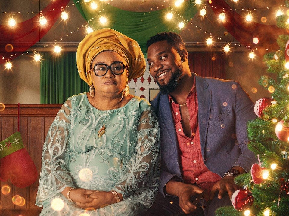 woman and man sitting around christmas lights