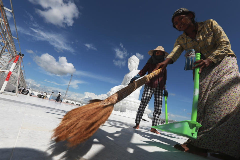 Laborers sweep near the sitting Maravijaya Buddha statue made with marble rock, Friday, July 21, 2023, in Naypyitaw, Myanmar. The Maravijaya Buddha statue is said to be the world’s highest sitting marble Buddha image according to local media. (AP Photo/Aung Shine Oo)