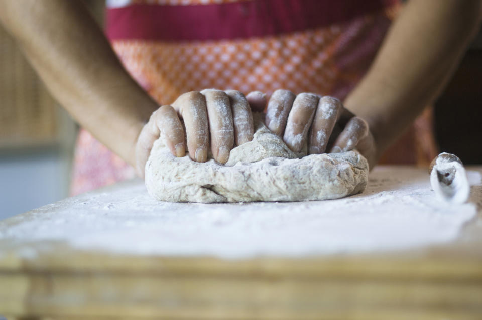 person kneading bread dough