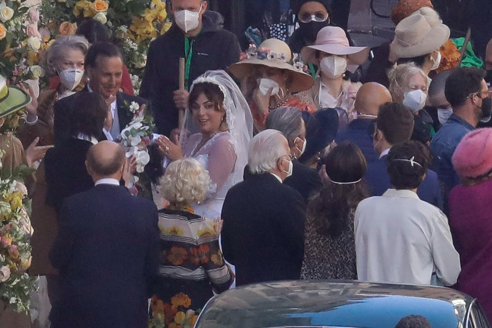 Lady Gaga, wearing a wedding dress in background left, plays Maurizio Gucci's former wife Patrizia Reggiani during the shooting of a movie by Ridley Scott, based on the story of the murder of Maurizio Gucci in 1995, in Rome, Thursday, April 8, 2021. (AP Photo/Andrew Medichini)