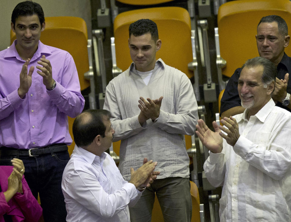 ARCHIVO - Elián González, en el centro, es reconocido con aplausos durante una sesión legislativa en la Asamblea Nacional en La Habana, Cuba, el 20 de diciembre de 2014. (AP Foto/Ramón Espinosa, Archivo)