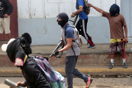 Demonstrators, one of them holding a shotgun, take part in a protest against the government of Nicaraguan President Daniel Ortega in Masaya, Nicaragua June 19, 2018. REUTERS/Oswaldo Rivas