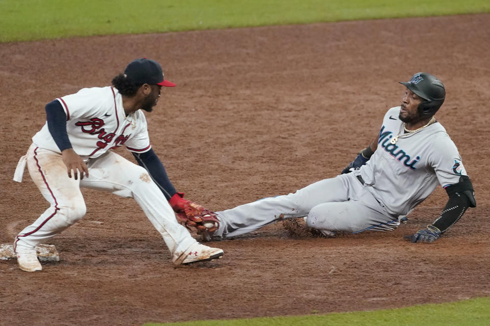 Miami Marlins' Starling Marte is tagged out at second by Atlanta Braves second baseman Ozzie Albies as he tries to stretch a single during the ninth inning of a baseball game Friday, Sept. 25, 2020, in Atlanta. (AP Photo/John Bazemore)