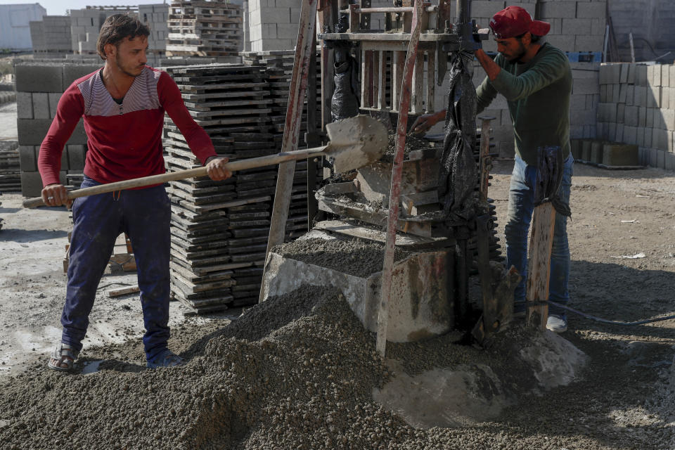 Palestinian workers make concrete bricks from recycled rubble of buildings to be used in reconstruction of buildings that were damaged by Israeli airstrikes during Israel's war with Gaza's Hamas rulers last May, at a brick factory east of Gaza City, Jan. 6, 2022. The Gaza Strip has few jobs, little electricity and almost no natural resources. But after four bruising wars with Israel in just over a decade, it has lots of rubble. Local businesses are now finding ways to cash in on the chunks of smashed concrete, bricks and debris left behind by years of conflict. (AP Photo/Adel Hana)