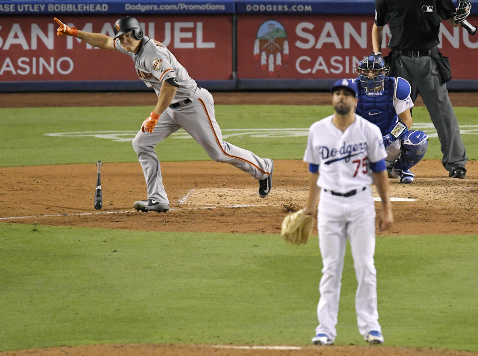 San Francisco Giants' Nick Hundley, left, celebrates as he hits a two-RBI single as Los Angeles Dodgers relief pitcher Scott Alexander, center, watches along with catcher Austin Barnes during the ninth inning of a baseball game, Monday, Aug. 13, 2018, in Los Angeles. (AP Photo/Mark J. Terrill)