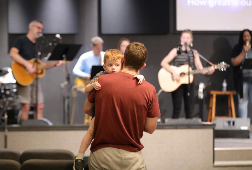 Jerry Csaki, a member of Alliance Christian Center, holds his son Silas, 3, as the church's praise team leads attendees in song Thursday, May 2, 2024, at the National Day of Prayer program at Alliance Christian Center.