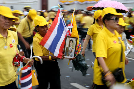 People carry flags and a portrait of King Maha Vajiralongkorn outside the balcony of Suddhaisavarya Prasad Hall at the Grand Palace, where he will grant a public audience to receive the good wishes of the people in Bangkok, Thailand May 6, 2019. REUTERS/Athit Perawongmetha