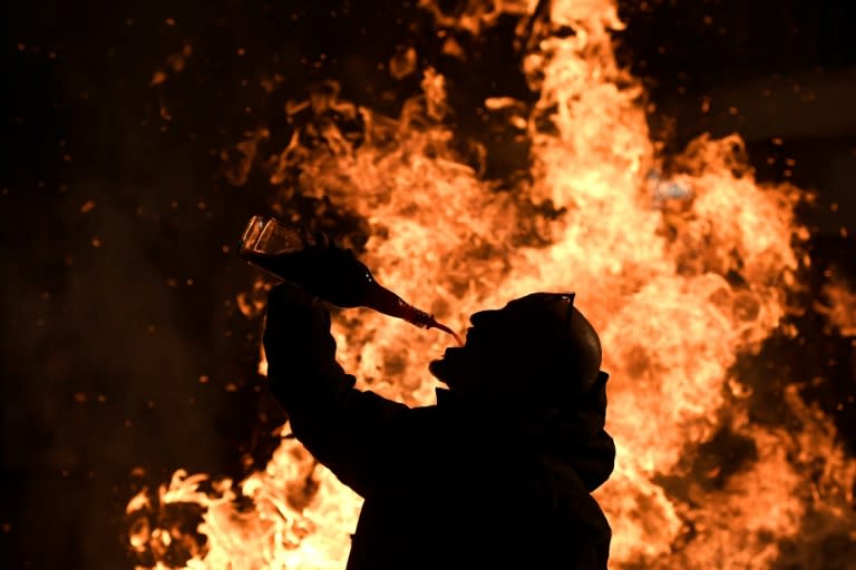 A man drinks near a bonfire during the age-old festival of Las Luminarias in San Bartolome de Pinares