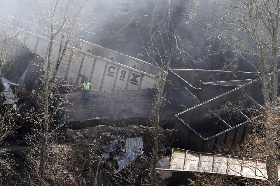 Smoke fills the sky after an empty CSX coal train hit a rockslide along tracks causing a fiery derailment on Wednesday, March 8, 2023 in a remote area just south of Sandstone, W.Va. Four locomotives and 22 empty cars derailed in Summers County near the New River, CSX said. The lead locomotive, which carried a conductor, an engineer and an engineer trainee, caught fire and the crewmembers were being evaluated and treated for non-life threatening injuries, the company said. (Jenny Harnish/The Register-Herald via AP)