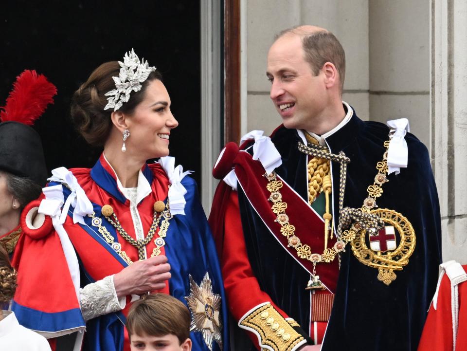 Kate Middleton and Prince William look at each other on the balcony of Buckingham Palace after the coronation of King Charles