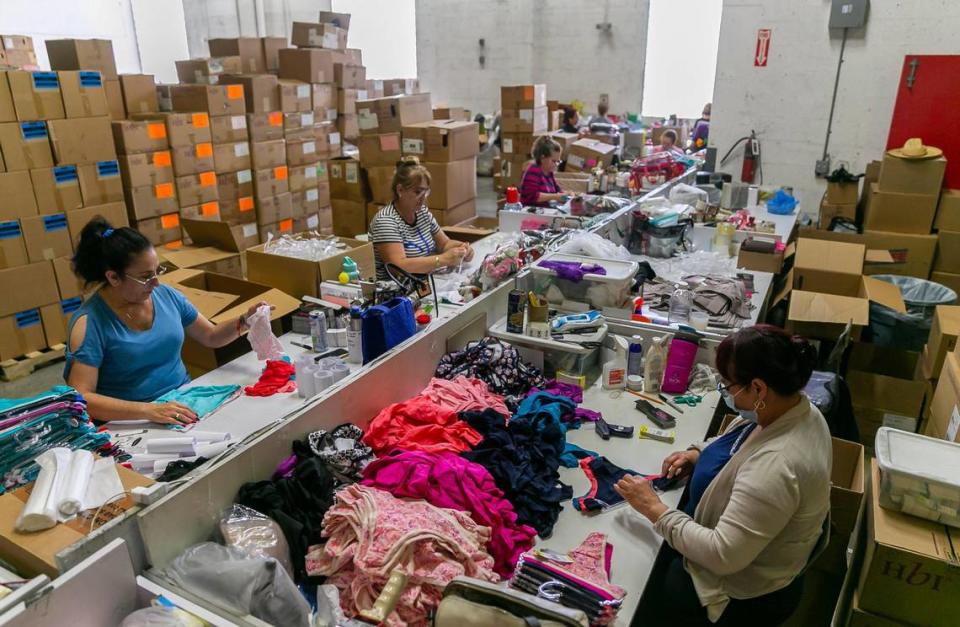 Atlantic Hosiery employees pack clothing articles inside a warehouse attached to their employer’s storefront. The company is opening rental space to vendors from the Opa-locka Hialeah Flea Market, who were recently given eviction notices.