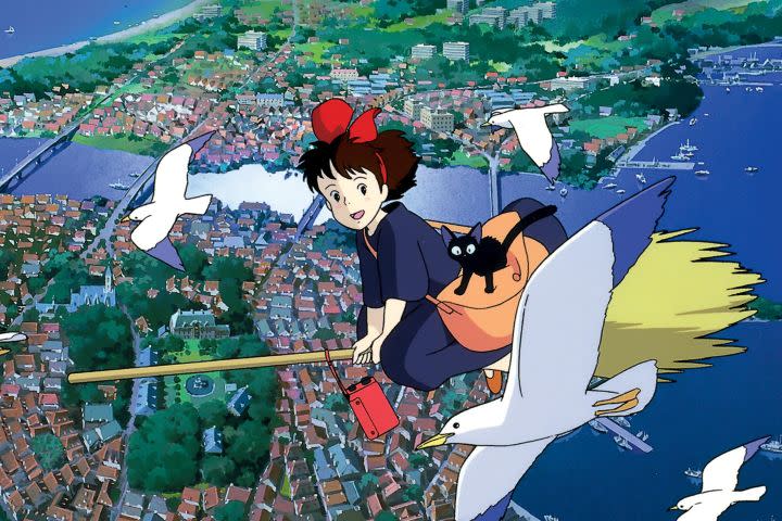 Kiki and her cat flying over the city on her broom in Kiki's Delivery Service.
