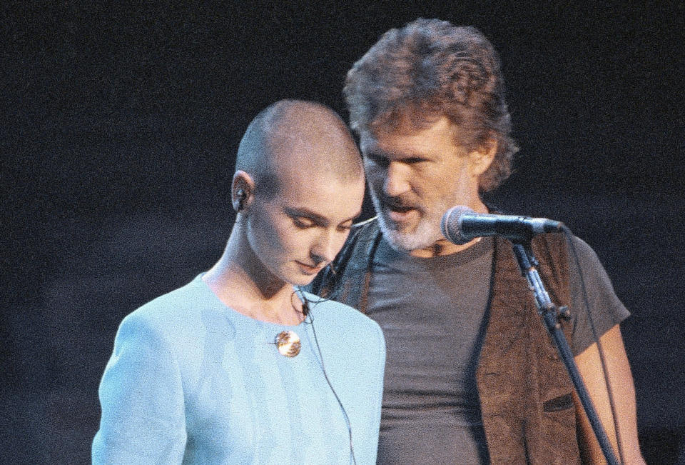 Kris Kristofferson comforts O'Connor after she was booed off stage during the Bob Dylan anniversary concert at New York Madison Square Garden, Oct. 17, 1992, following her controversial SNL appearance. (AP Photo/Ron Frehm)