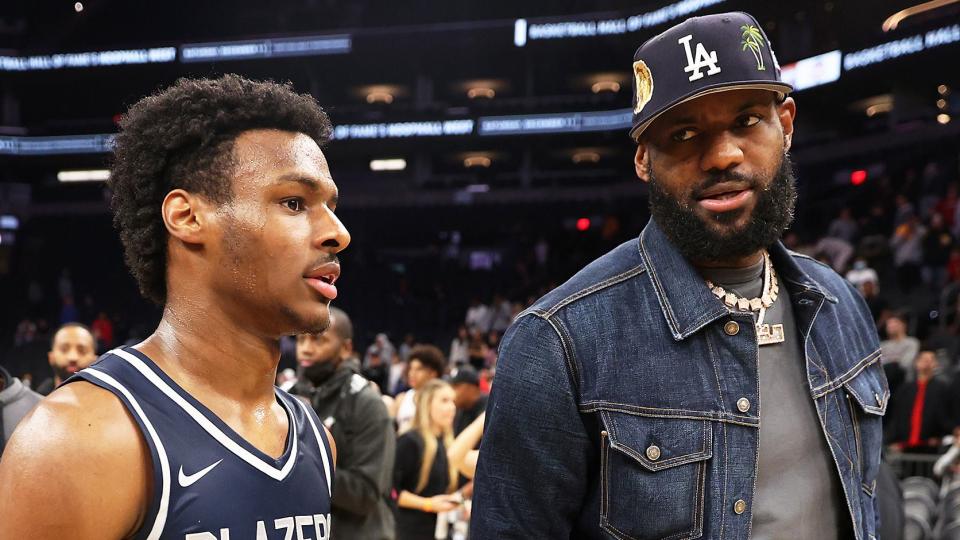 Bronny James #0 of the Sierra Canyon Trailblazers and father LeBron James of the Los Angeles Lakers walk off the court following the Hoophall West tournament at Footprint Center on December 11, 2021 in Phoenix, Arizona.