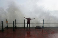 <p>A woman stands as waves crash against the sea wall at Penzanze, Cornwall southwestern England, as the remnants of Hurricane Ophelia begins to hit parts of Britain and Ireland. Ireland’s meteorological service is predicting wind gusts of 120 kph to 150 kph (75 mph to 93 mph), sparking fears of travel chaos. Some flights have been cancelled, and aviation officials are warning travelers to check the latest information before going to the airport Monday. (Photo: Ben Birchall/PA via AP) </p>