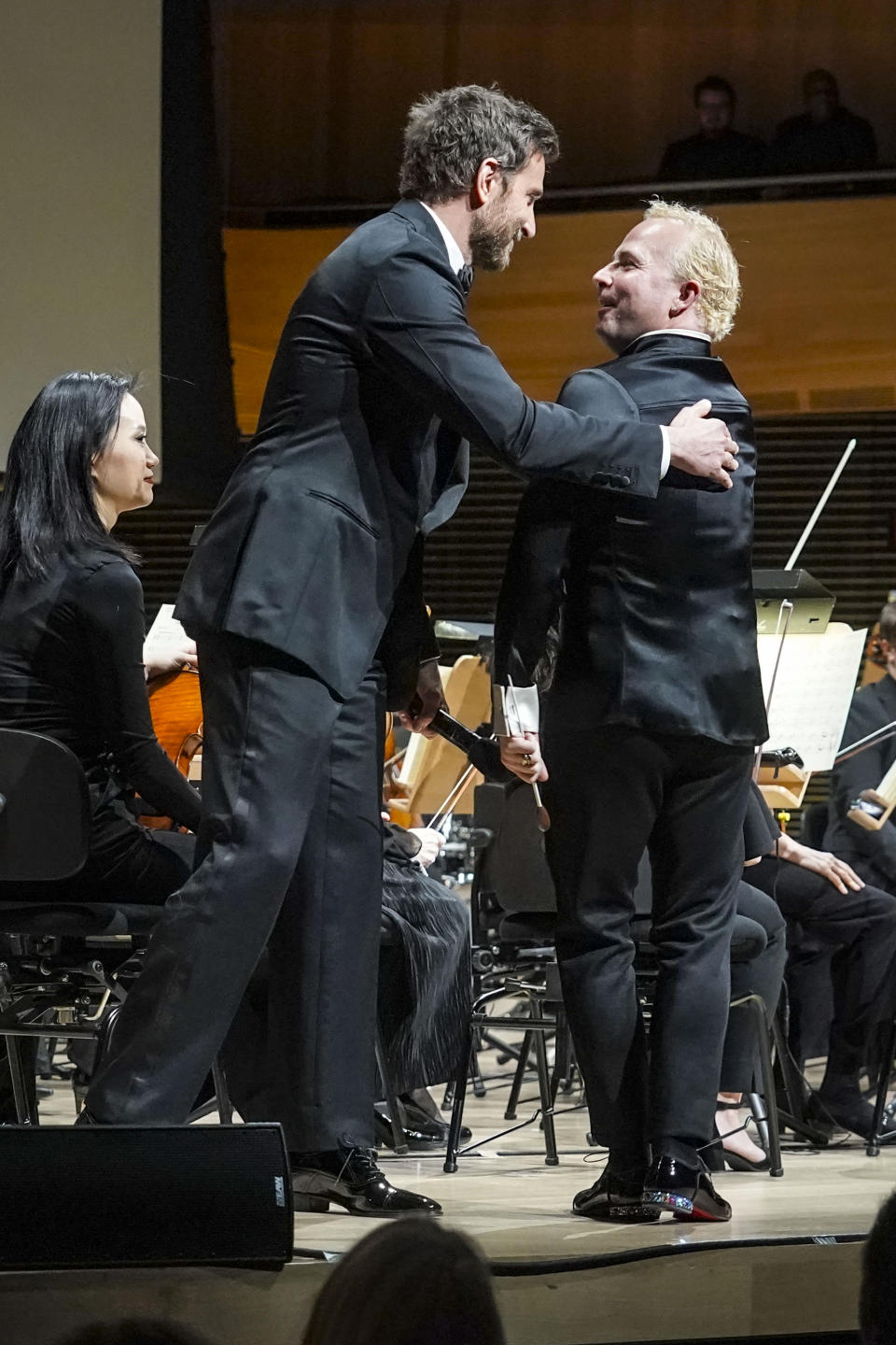 Actor and director Bradley Cooper, left, welcomes to the stage Metropolitan Opera's new music director Yannick Nézet-Séguin, right, in his debut as conductor for the New York Philharmonic, Wednesday, Feb. 14, 2024, in New York. (AP Photo/Bebeto Matthews)