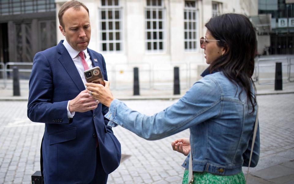 The Health Secretary looks at the phone of his aide Gina Coladangelo - TOLGA AKMEN/AFP