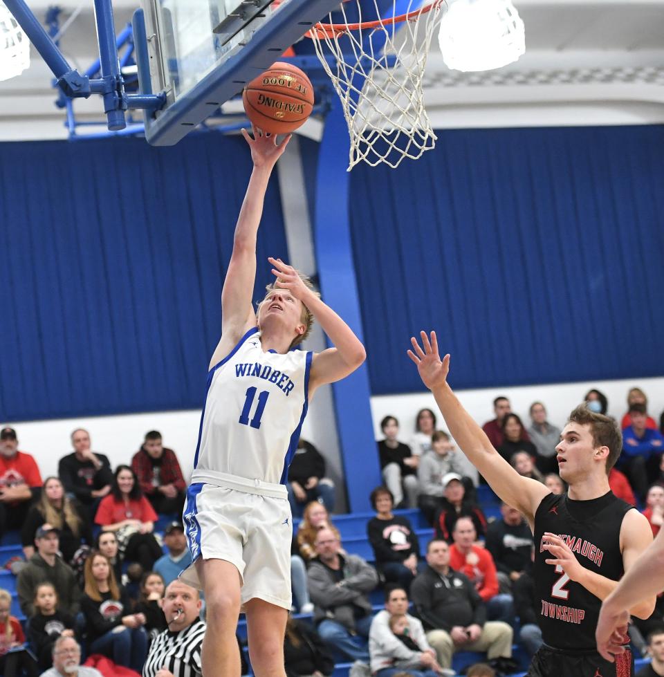 Windber's Caden Dusack (11) goes in for a layup in front of Conemaugh Township's John Updyke during a WestPAC boys basketball contest, Thursday, in Windber.