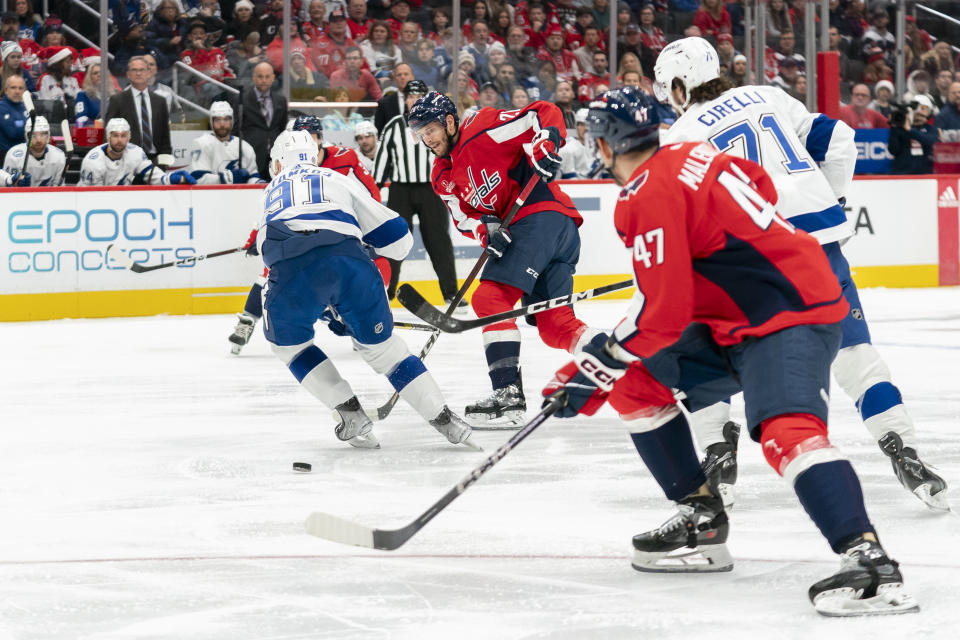 Washington Capitals right wing Nic Dowd (26) passes the puck to Capitals left wing Beck Malenstyn (47) in front of Tampa Bay Lightning center Steven Stamkos (91) during the first period of an NHL hockey game, Saturday, Dec. 23, 2023, in Washington. (AP Photo/Stephanie Scarbrough)