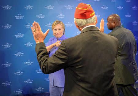 Democratic presidential nominee Hillary Clinton winks at the National Commander of the American Legion Dale Barnett after she addressed the National Convention in Cincinnati, Ohio, U.S., August 31, 2016. REUTERS/Bryan Woolston