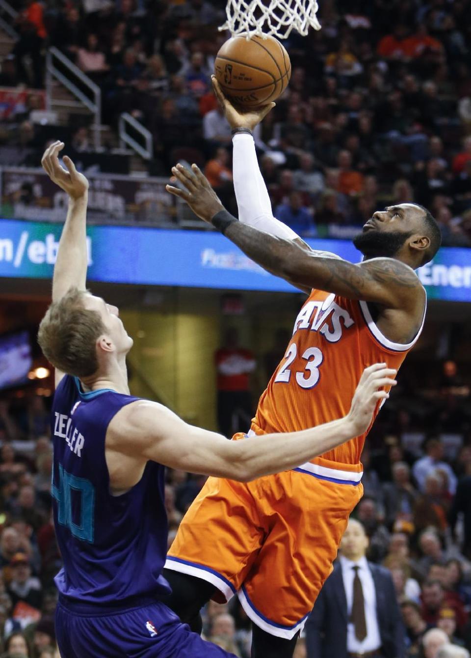 Cleveland Cavaliers' LeBron James (23) scores over Charlotte Hornets' Cody Zeller (40) during the first half of an NBA basketball game Saturday, Dec 10, 2016, in Cleveland. (AP Photo/Ron Schwane)