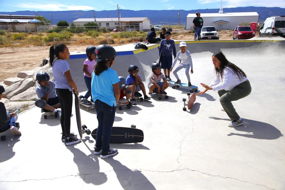 Instructor Diorr Greenwood, right, demonstrates the proper posture for riding a skateboard to participants during the opening session of the Modern Matriarch Skate Jam Friday, Sept. 22 at the Two Grey Hills Skate Park in Two Grey Hills on the Navajo Nation.