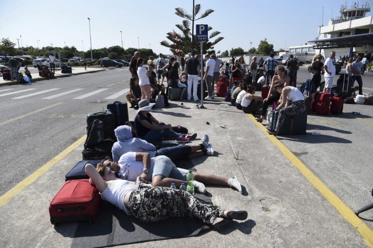 Passengers gather outside the airport after the cancelation of many flights on the Greek island of Kos on Friday, July 21, 2017 (Nikos Christofakis/InTime News via AP)
