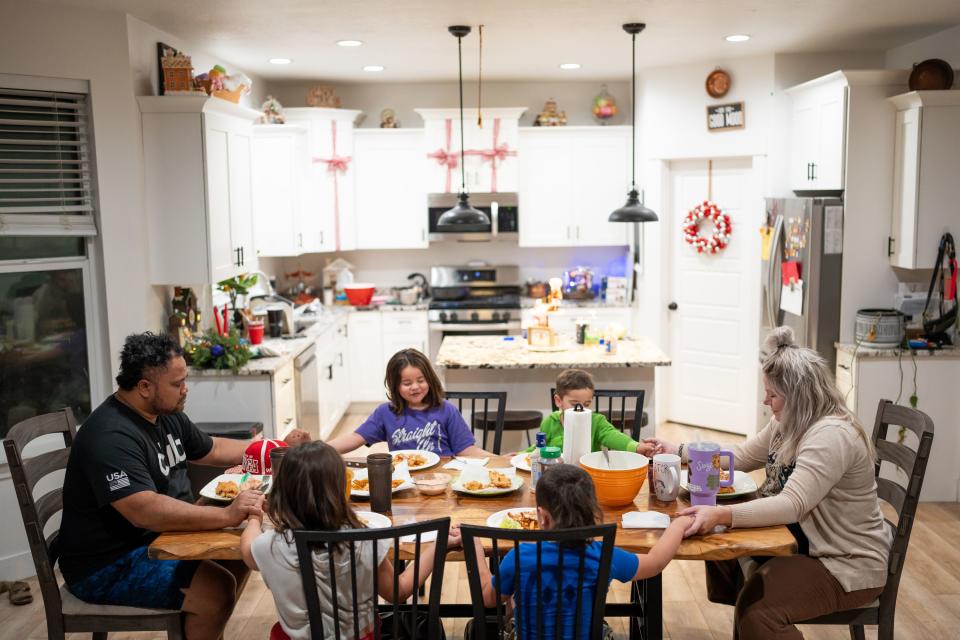 Maka and Jessica Palu and their children, clockwise from top left, Lini, 5; Joey, 3; “Bubba,” 4; and Fine, 7, pray before eating dinner at their home in Eagle Mountain on Tuesday, Nov. 28, 2023. | Spenser Heaps, Deseret News