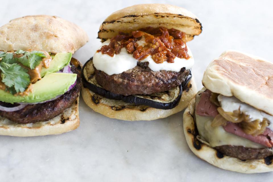 In this image taken on June 10, 2013, from left, The Thai, The Eggplant Parm, and The New Yorker burgers are shown in Concord, N.H. (AP Photo/Matthew Mead)