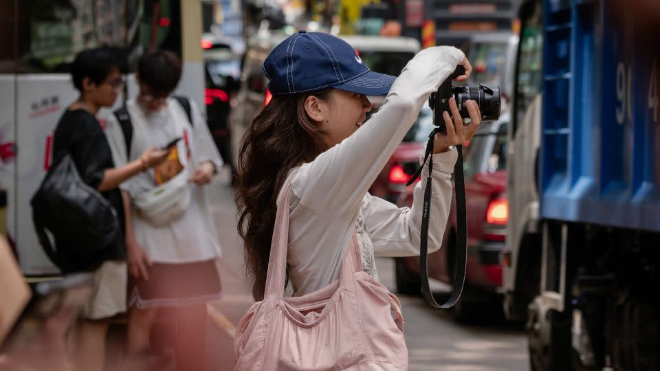 A woman takes pictures at an iconic Xiaohongshu spot in Hong Kong. - Noemi Cassanelli/CNN