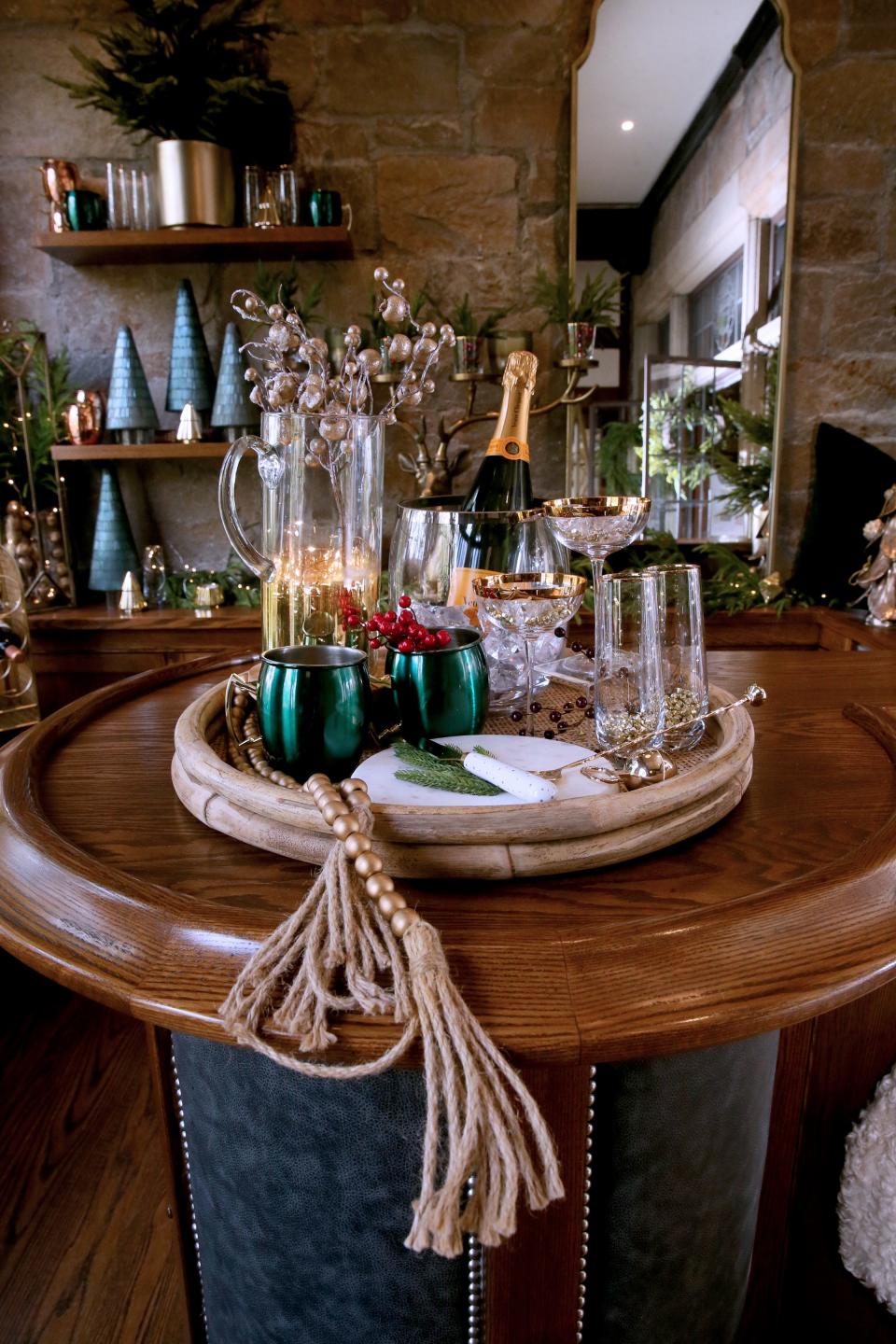 Emerald colored mugs accent the bar in the pub theme room designed by Crane & Arrow at this year’s Christmas Fantasy House.